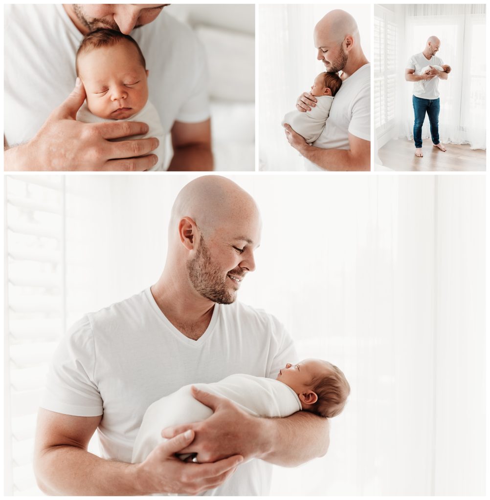 father holding baby boy for newborn photos