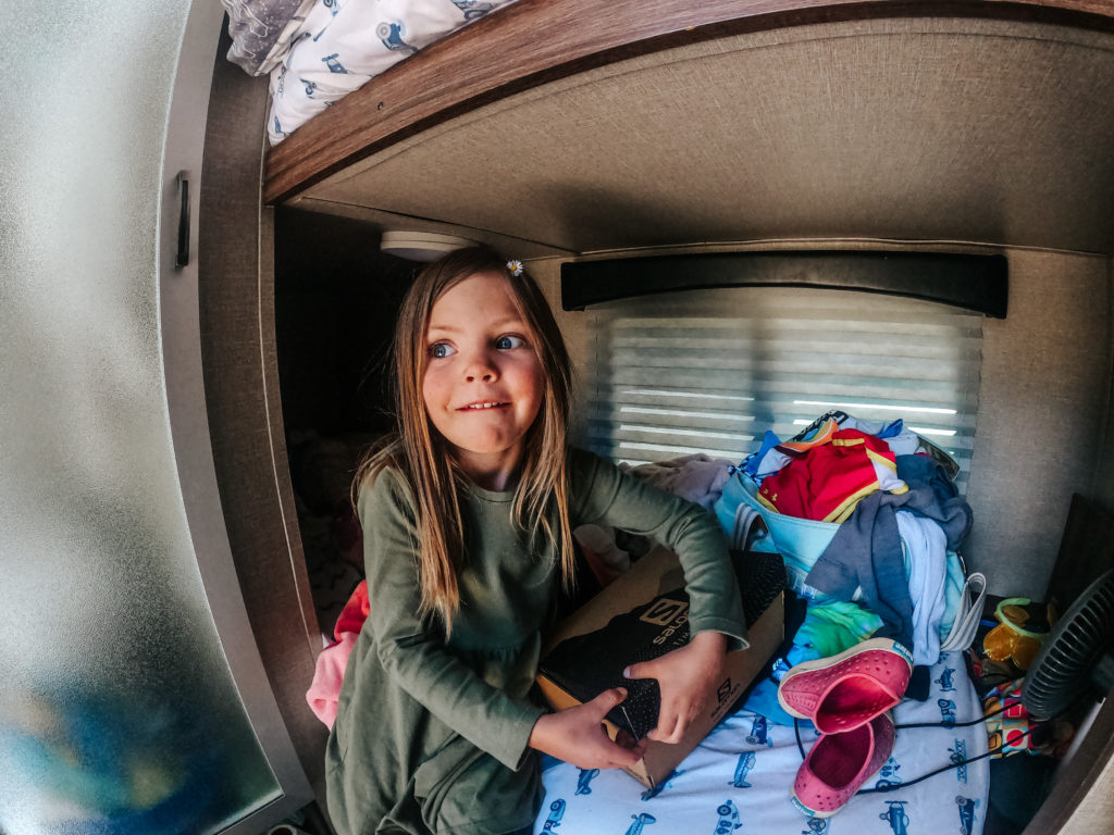 Girl sitting in her bunk bed in RV camping in Colorado