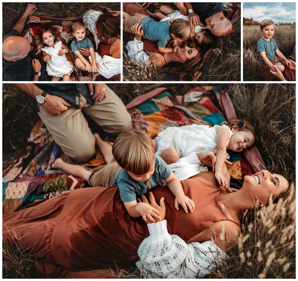 family snuggles on a blanket in a field after sunset