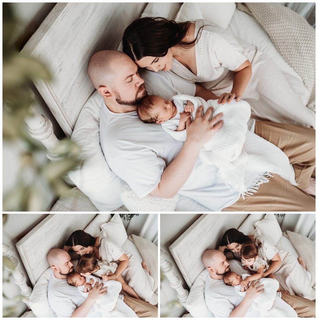 family snuggled with newborn boy on bed in castle rock newborn photo studio