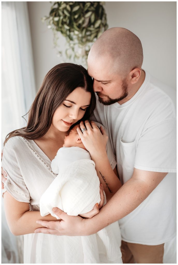 parents holding their baby in castle rock newborn photo studio