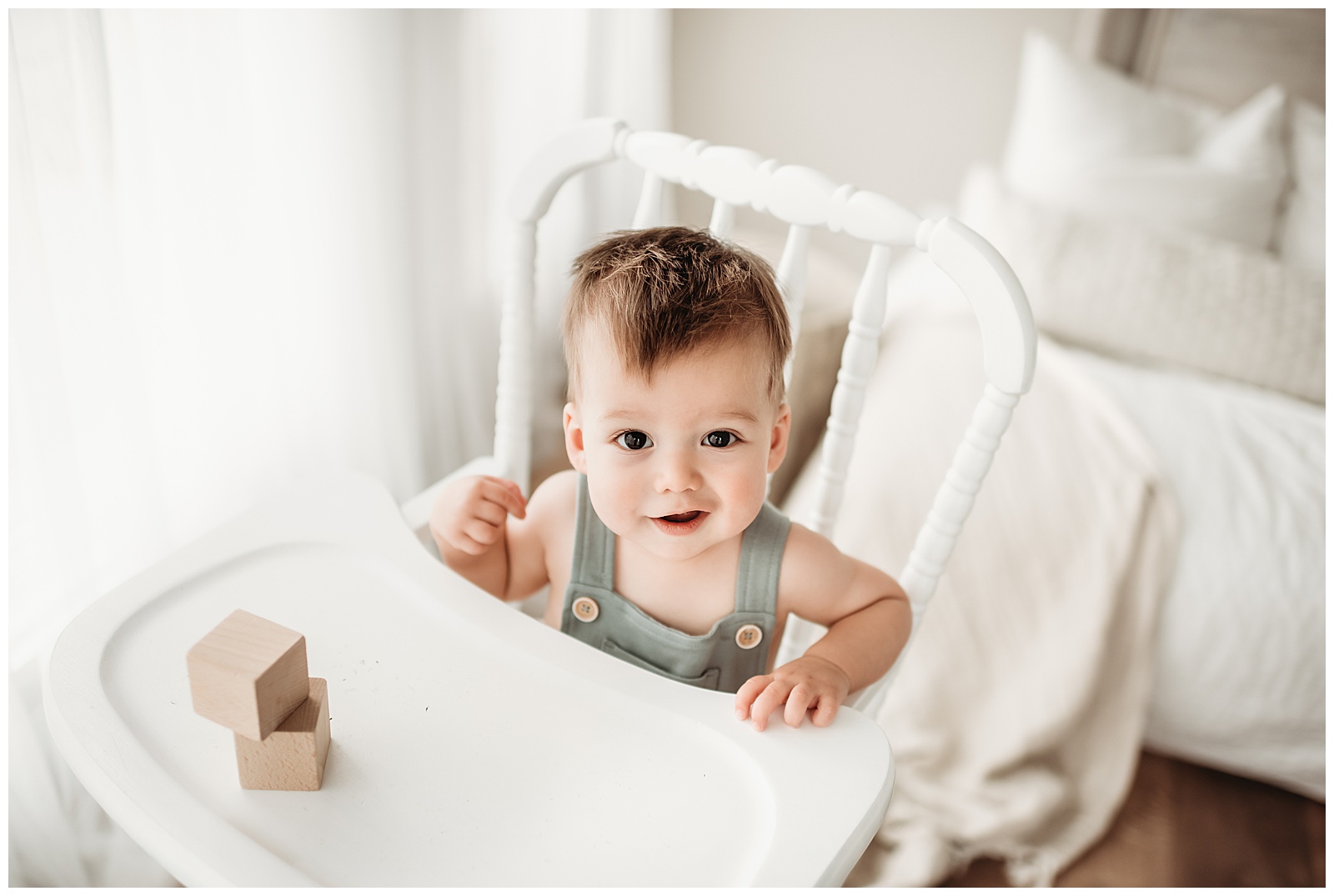 baby boy sitting at white high chair with blocks in denver