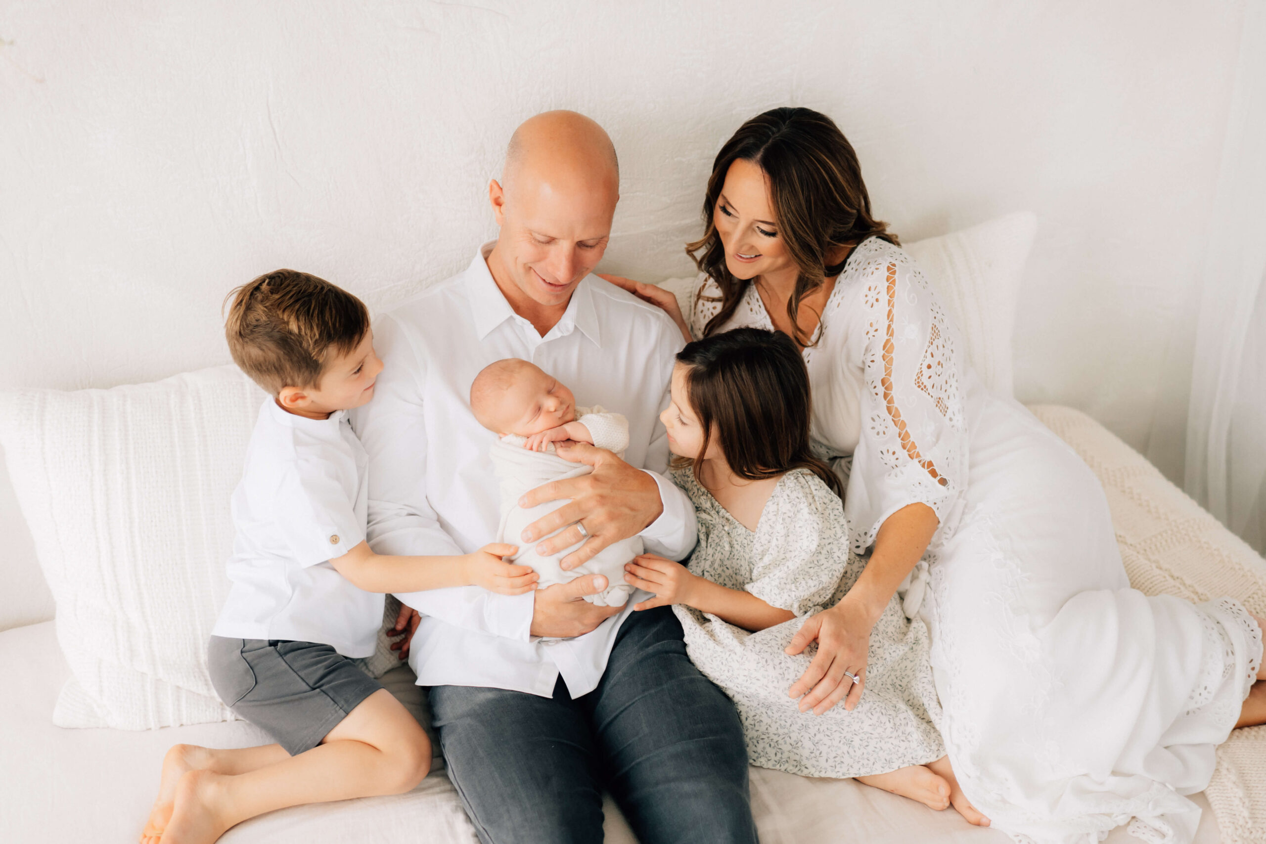 newborn photographer session with mom dad and two older siblings after booking session